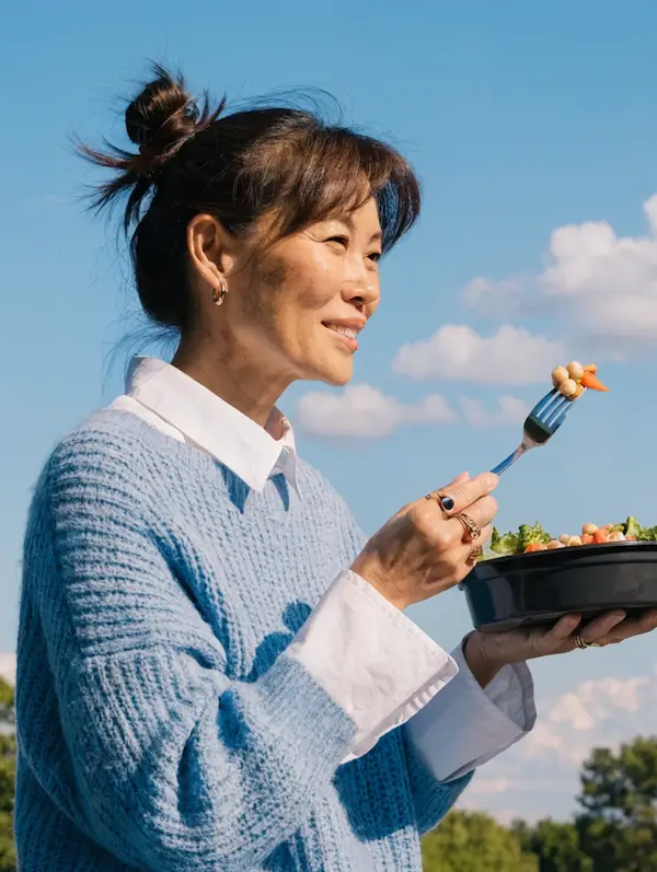 Woman eating Nuvi meal outdoors