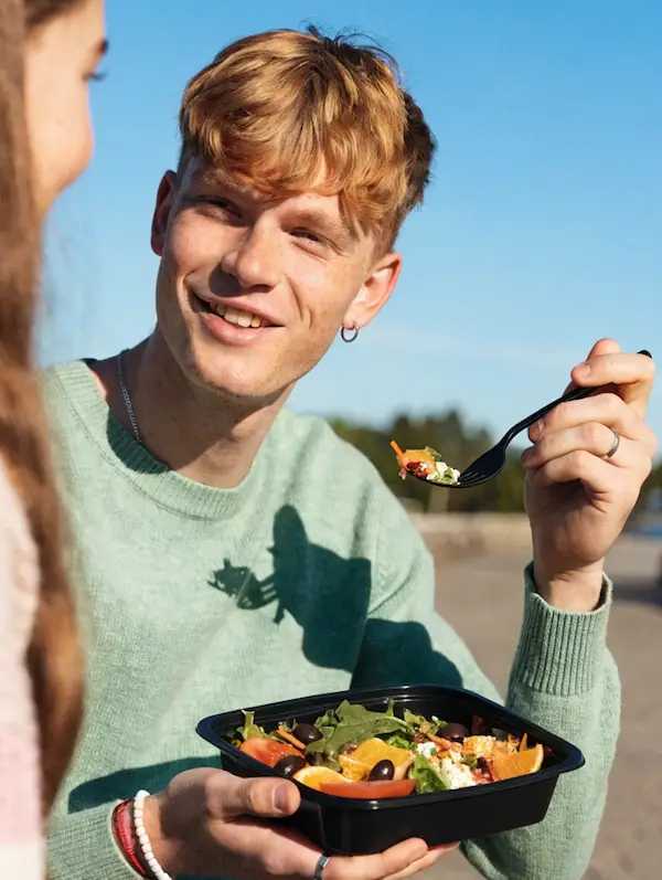 Person enjoying Nuvi salad outdoors